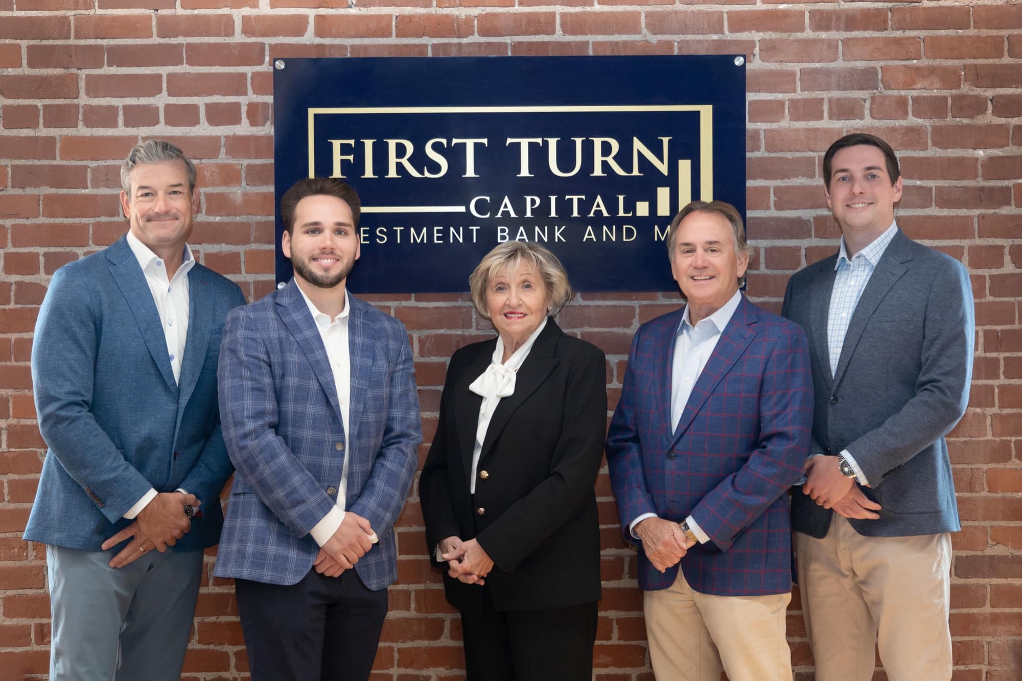 The First Turn Capital team in front of the firm's sign: Chad Godwin, Caleb Corbitt, Beverly Johnson, Doug Franklin, and Gray Katigan